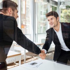 graphicstock-two-happy-successful-young-businessmen-standing-and-shaking-hands-on-business-meeting_rdzlG_mH3x_thumb