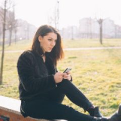 graphicstock-young-handsome-brunette-caucasian-girl-using-a-smartphone-connected-online-in-a-park-in-the-city-tecnology-connectivity-e-commerce-business-social-network-concepts_SakYDfK1W_thumb