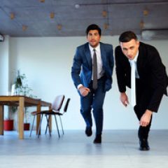 two-businessman-running-together-in-office-business-concept_thumb