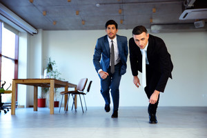 two-businessman-running-together-in-office-business-concept_thumb